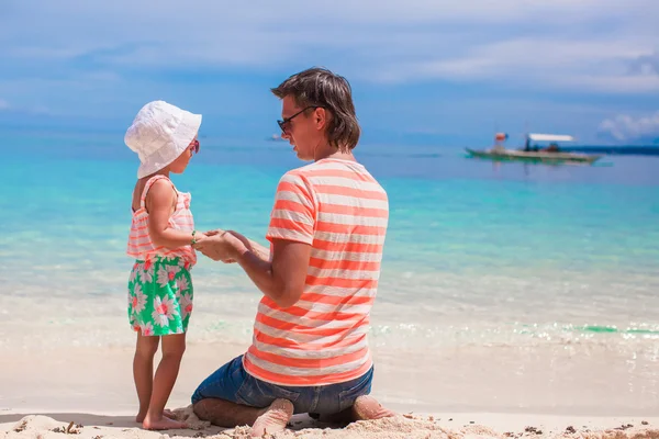 Adorable girl and young man on white sandy beach — Stock Photo, Image