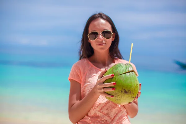 Jovem com coquetel de coco na praia — Fotografia de Stock