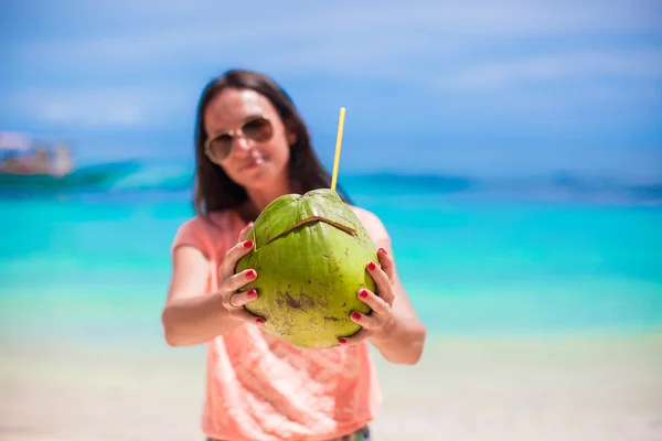Młoda kobieta z kokos koktajl na plaży — Zdjęcie stockowe