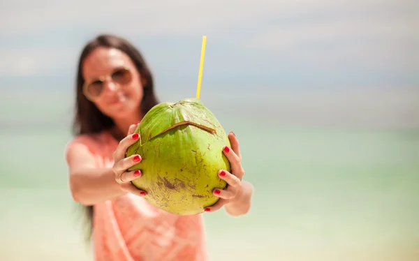 Gros plan une noix de coco dans les mains de jeune fille heureuse — Photo