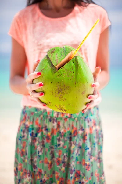 Primer plano verde grande coco en las manos de la mujer joven — Foto de Stock