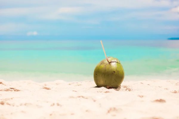 Coco no fundo da praia mar azul-turquesa e céu azul — Fotografia de Stock