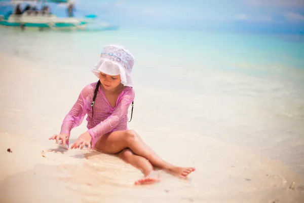 Adorable toddler girl at tropical beach playing with white sand — Stock Photo, Image