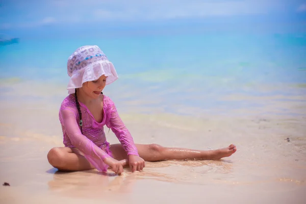 Kleines Mädchen spielt an einem heißen, sonnigen Tag im Sand — Stockfoto