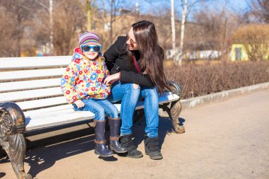 genç anne ve küçük mutlu kız güneşli bir gün spring Park'ta rahatlayın