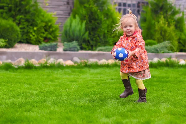 Lilla söta tjejen som spelar boll på gården — Stockfoto