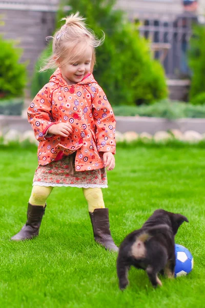 Cute dziewczynka gra z jej szczeniaka w stoczni — Zdjęcie stockowe