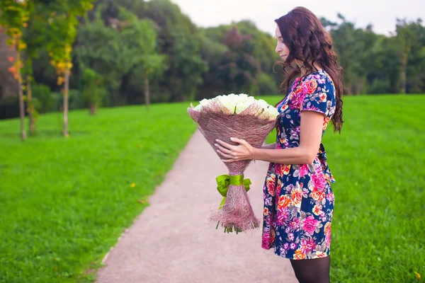 Hermoso ramo de rosas blancas grandes a manos de una joven en vestido de color — Foto de Stock