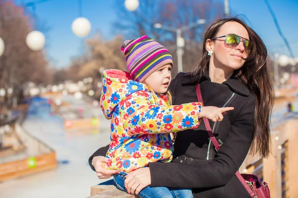 Jonge moeder en beetje blij meisje ontspannen in voorjaar park in zonnige dag — Stockfoto