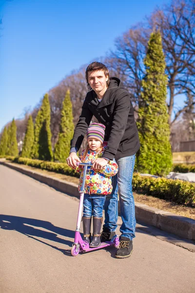 Menina bonito e feliz pai andando no parque de primavera em um dia ensolarado — Fotografia de Stock