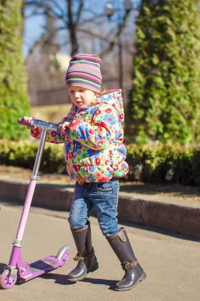 Adorable petite fille s'amuser sur le scooter dans la chaude journée de printemps — Photo