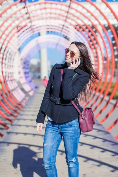 Молодая красивая счастливая женщина разговаривает по телефону на открытом воздухе — стоковое фото
