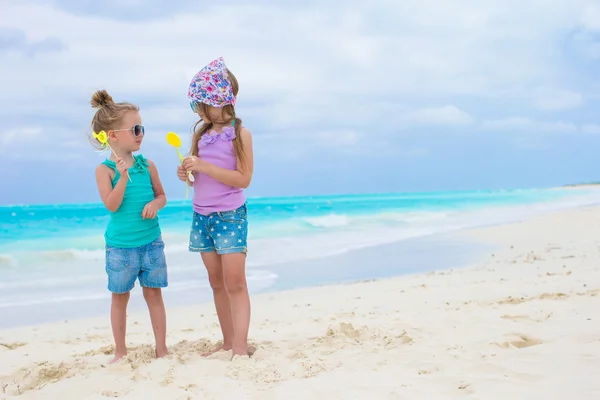 Little adorable girls with eggs on white tropical beach — Stock Photo, Image