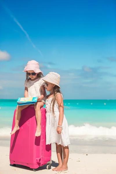 Petites jolies filles avec une grande valise et une carte à la recherche de la route sur la plage tropicale — Photo