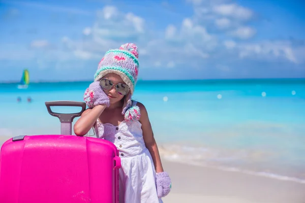 Niña adorable en cálido sombrero de invierno y guantes en una playa tropical —  Fotos de Stock