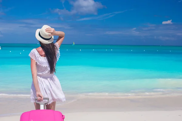 Jonge mooie vrouw met grote koffer op tropisch strand — Stockfoto
