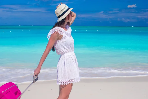 Mladá krásná žena chůze se zavazadly na tropické pláži — Stock fotografie
