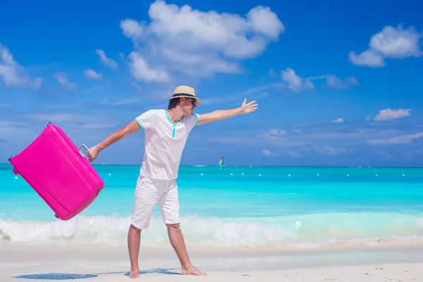 Young man walking with his bag on tropical white beach — Stock Photo, Image