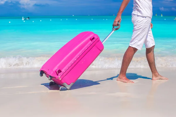 Close up a man pulls luggage on white sand — Stock Photo, Image