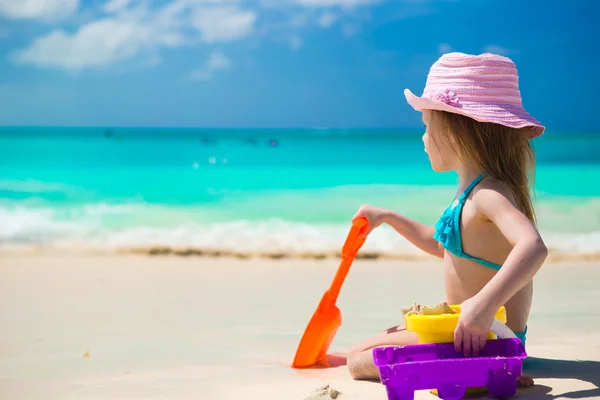 Entzückendes kleines Mädchen spielt am Strand mit weißem Sand — Stockfoto