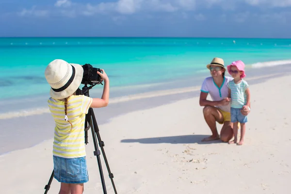 Little girl making photo of her dad and sister at the beach — Stock Photo, Image