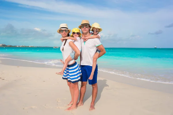 Joven familia de cuatro en vacaciones en la playa — Foto de Stock