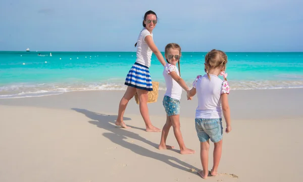 Mãe feliz e suas meninas adoráveis se divertindo na praia tropical — Fotografia de Stock