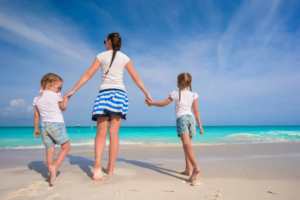 Young happy mother and her adorable daughters having fun at exotic beach on sunny day — Stock Photo, Image