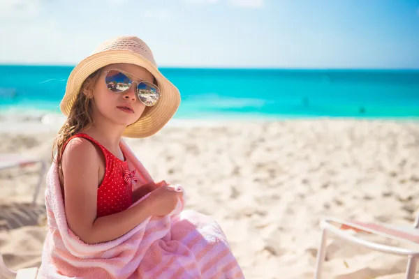 Beautiful little girl sitting on chair at beach during summer vacation — Stock Photo, Image