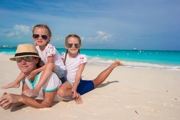 Glücklicher Vater und seine entzückenden kleinen Töchter am tropischen Strand — Stockfoto