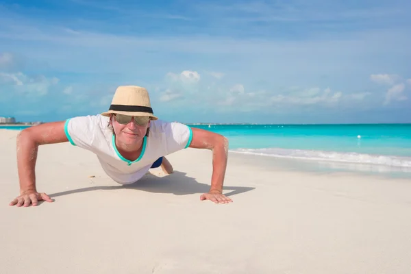 Joven haciendo flexiones en la playa perfecta — Foto de Stock