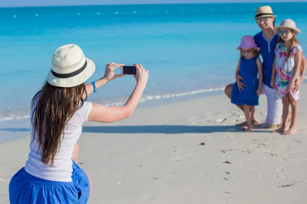 Genç anne telefon kumsaldaki ailesini fotoğraf yapma — Stok fotoğraf