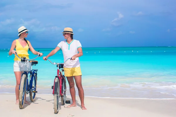 Joven pareja feliz con bicicletas en vacaciones de verano en la playa —  Fotos de Stock