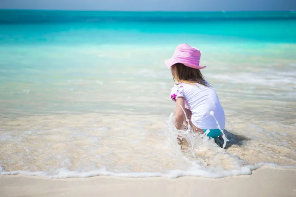 Linda niña jugando en aguas poco profundas en la playa exótica —  Fotos de Stock