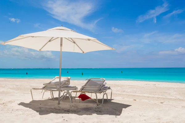 Ombrellone bianco e lettini sulla spiaggia tropicale — Foto Stock