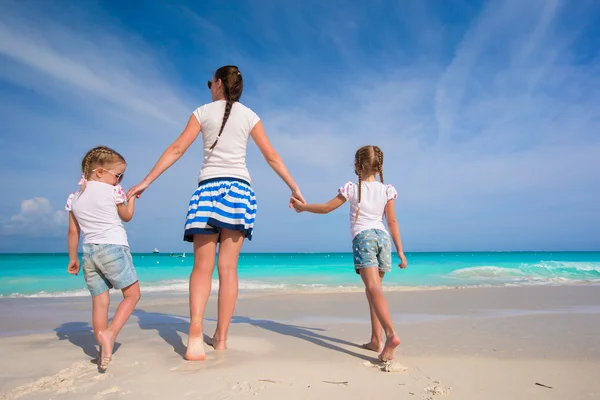 Joven madre feliz y sus adorables hijas se divierten en la playa exótica en el día soleado — Foto de Stock