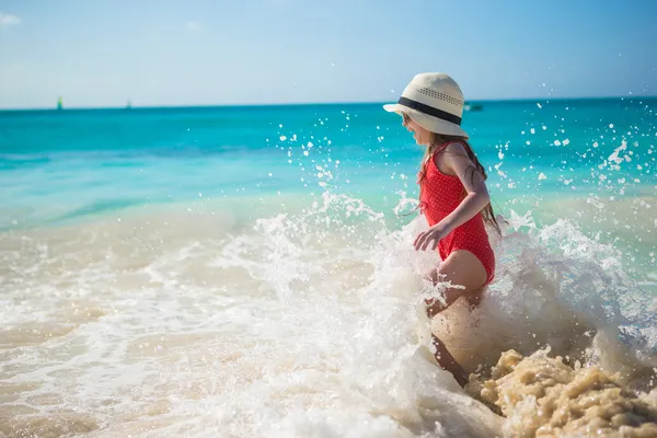 Rozkošná holčička hrát s vodou na pláži během karibské dovolené — Stock fotografie
