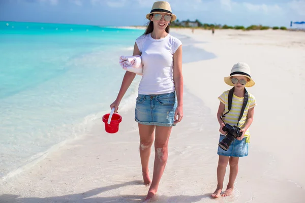 Ragazzina con macchina fotografica e giovane madre che cammina in spiaggia — Foto Stock