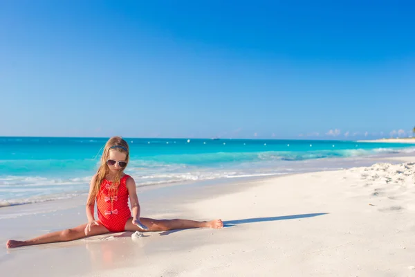 Niña sentada en la playa de arena blanca — Foto de Stock