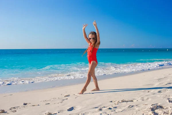 Söt gymnastiska liten flicka göra hennes övningar på tropisk strand — Stockfoto