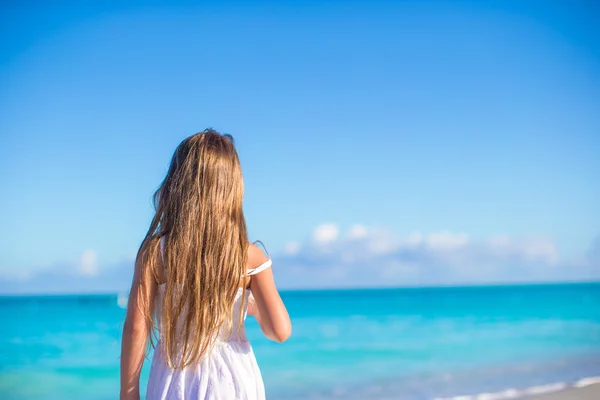 Visão traseira da adorável menina na praia branca durante as férias de verão — Fotografia de Stock