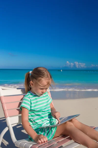 Niña adorable con portátil en la playa durante las vacaciones de verano — Foto de Stock