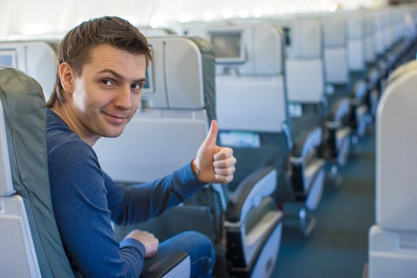 Homem feliz mostrando os polegares dentro da aeronave — Fotografia de Stock