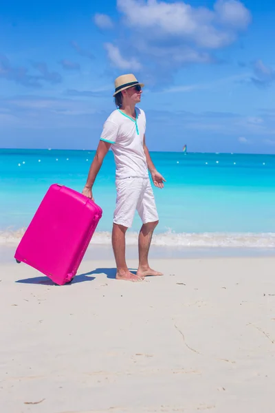 Młody podróżnik z jego bagażu na tropikalnej plaży — Zdjęcie stockowe