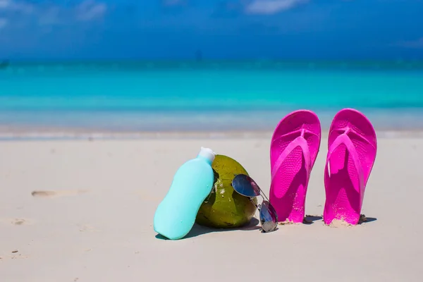 Flipflops, Kokosnuss und Sonnencreme auf weißem Sand — Stockfoto