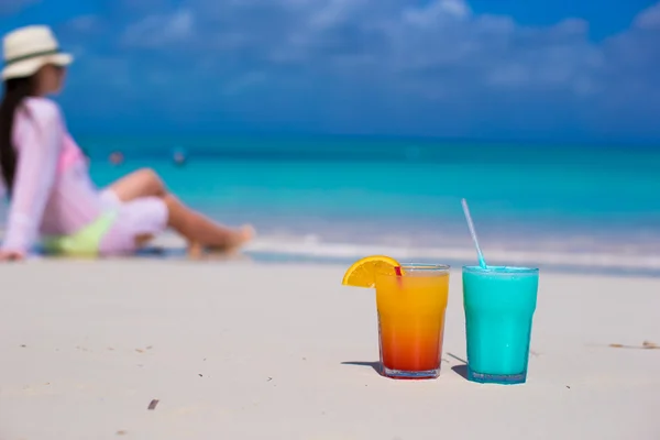 Close-up blauw curacao en mango cocktail op strand achtergrond jonge vrouw — Stockfoto