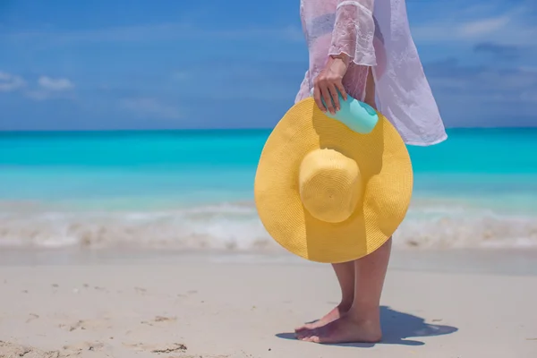 Close up a hat and suncream in the hands of women — Stock Photo, Image