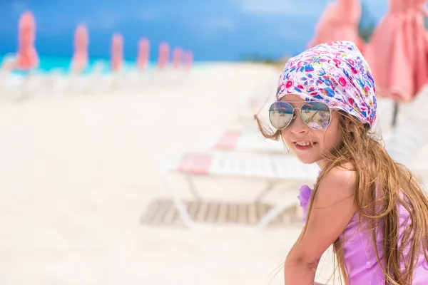 Schöne kleine Mädchen sitzt auf Strandkorb während der Sommerferien — Stockfoto