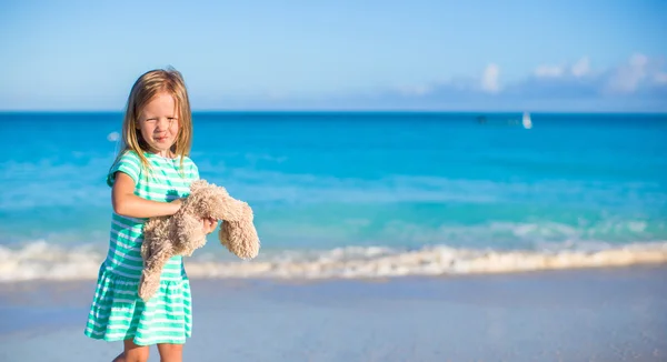 Rozkošná holčička s její zajíček hračka na tropické pláži dovolenou — Stock fotografie