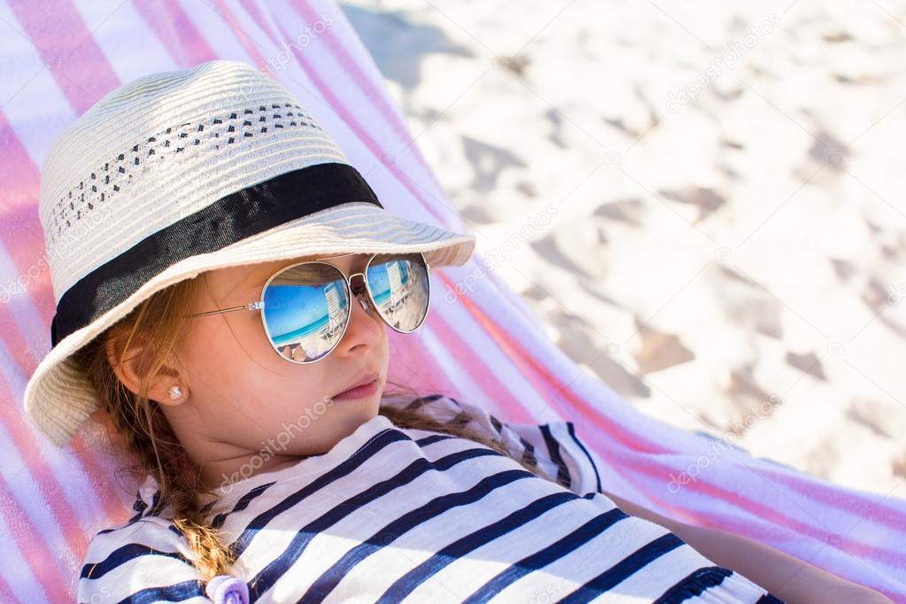 Portrait of little adorable girl lying on beach lounger